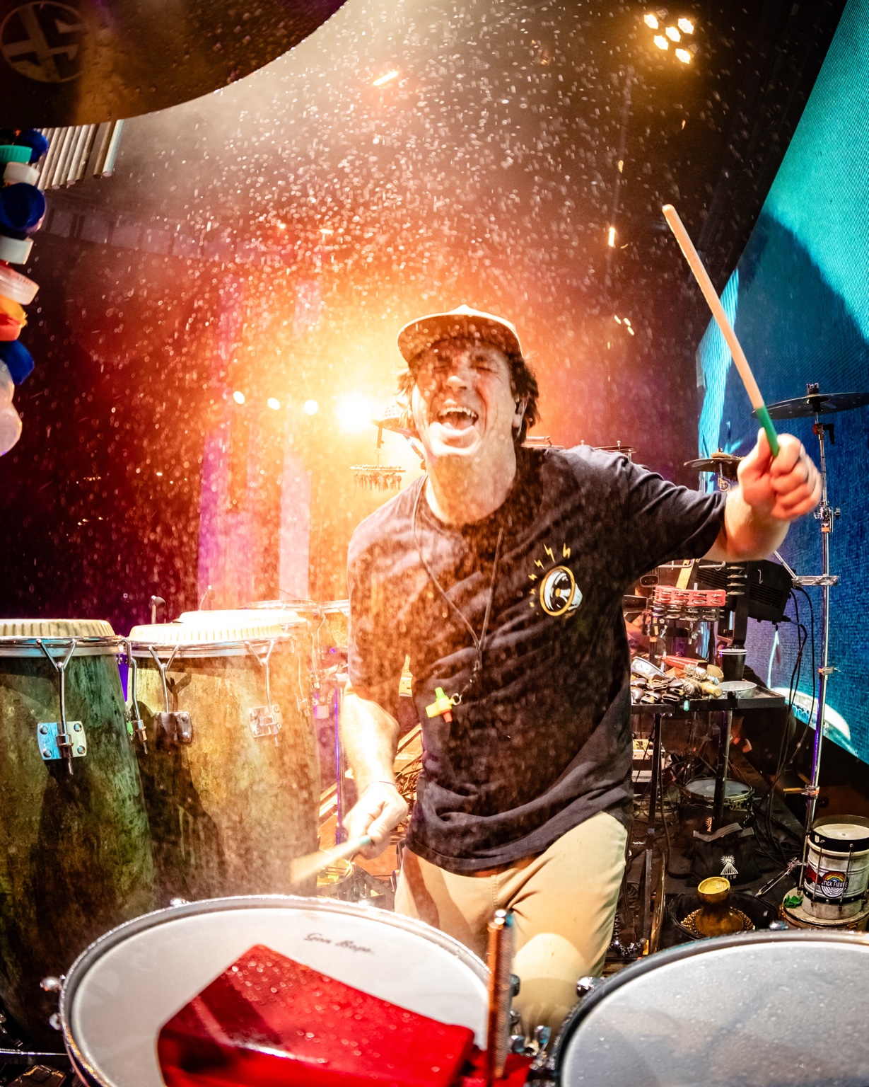 Will Phillips performing amid dramatic stage lights and water spray